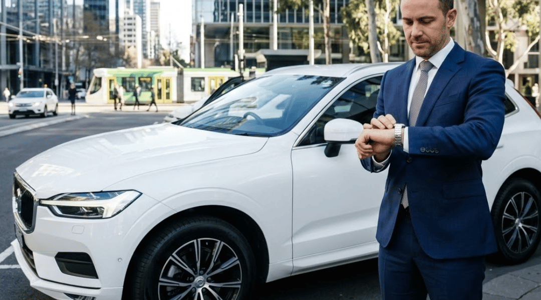 A pristine, white mid-size corporate SUV parked perfectly on a smooth, sealed asphalt surface in a modern Australian city business district.