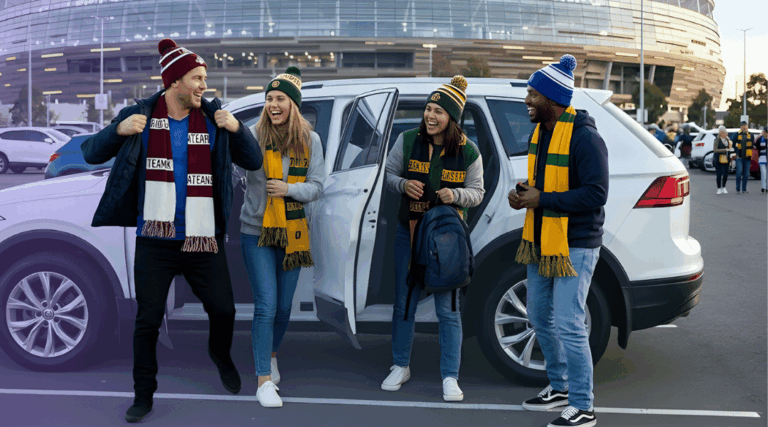 A group of excited fans wearing team colours getting out of their car in a stadium car park before a footy finals game.