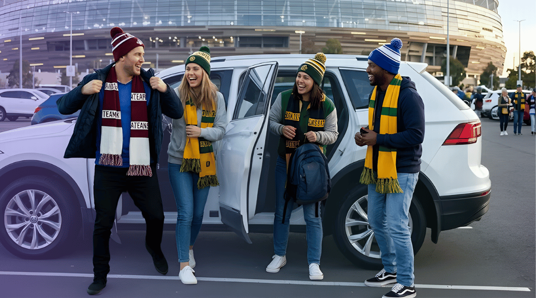 A group of excited fans wearing team colours getting out of their car in a stadium car park before a footy finals game.